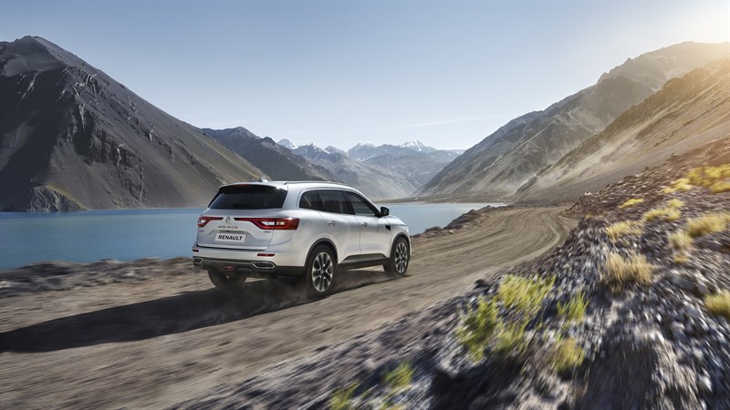 Renault KOLEOS - Vue de 3/4 arrière du véhicule sur une route rocailleuse près de la mer